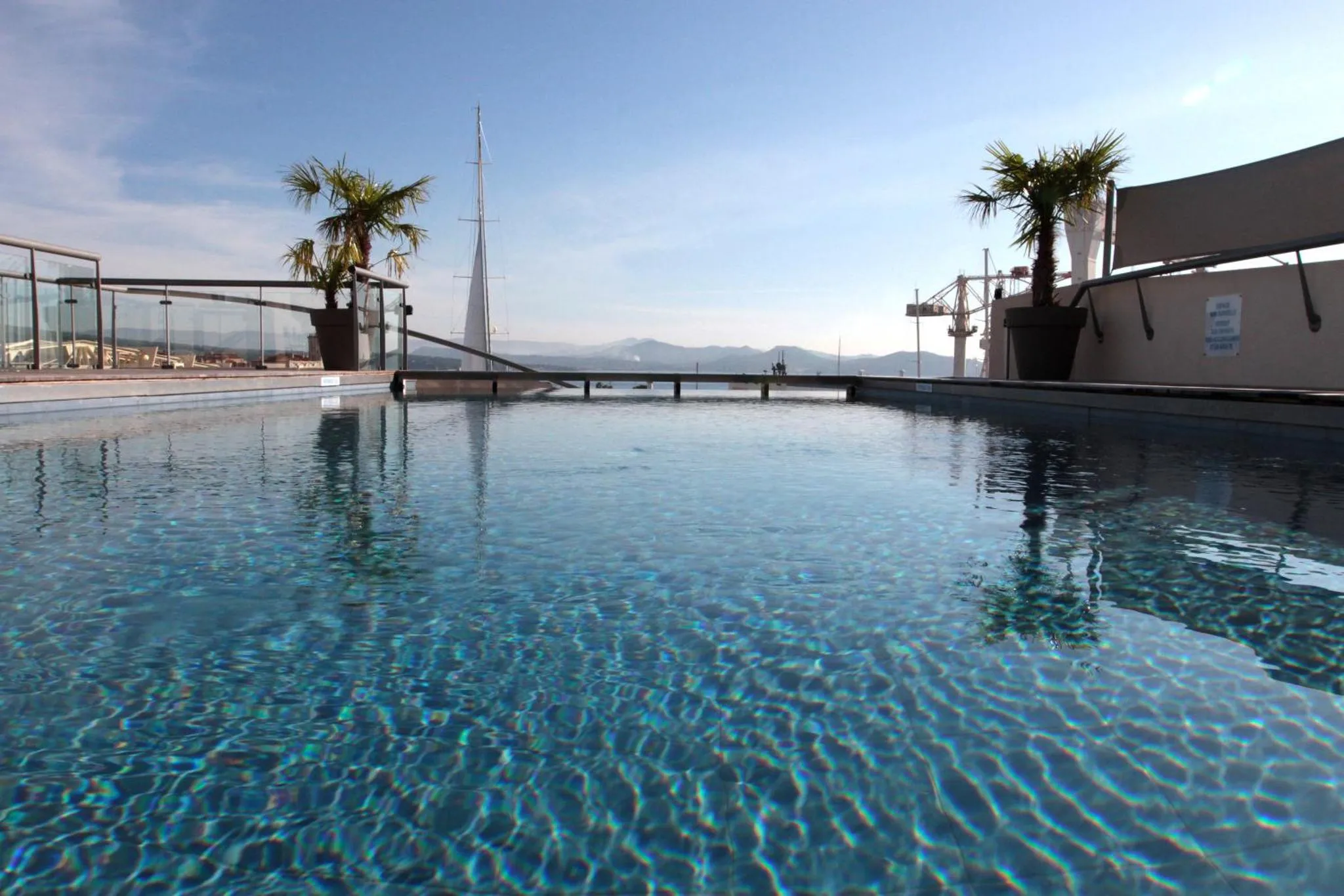 Piscine à débordement avec vue sur la mer et les montagnes.