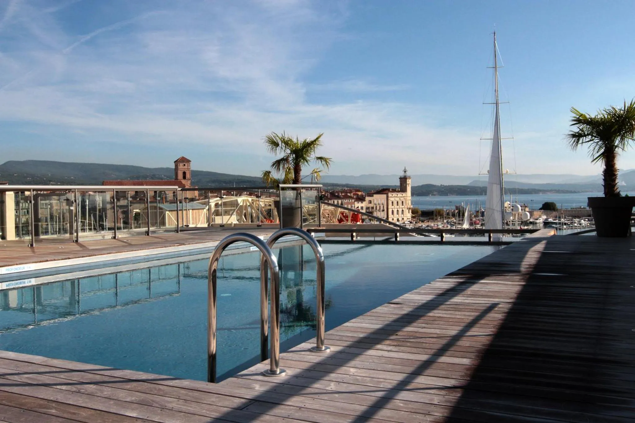 Une piscine sur le toit d'un bâtiment avec vue sur la mer et la ville.
