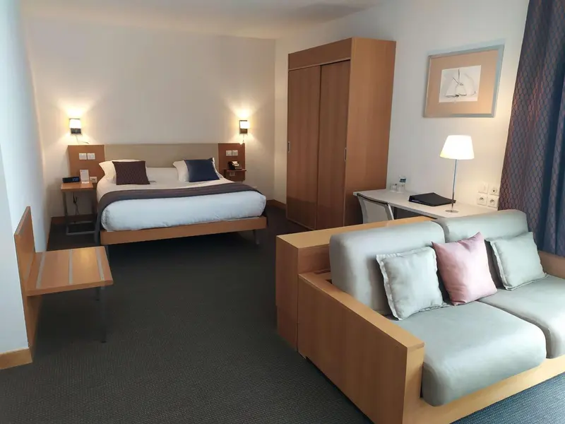 Une chambre d'hôtel moderne avec un lit et un coin salon.