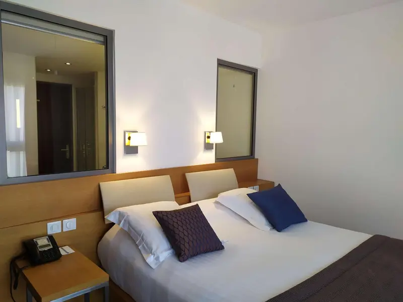 Une chambre d'hôtel avec un lit double et des lampes de chevet.