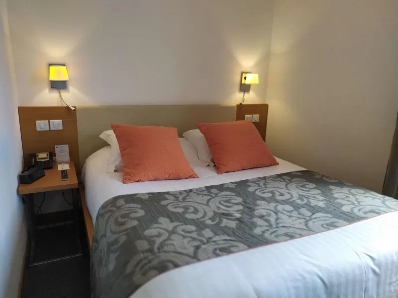 Une chambre avec un lit double et des oreillers décoratifs.