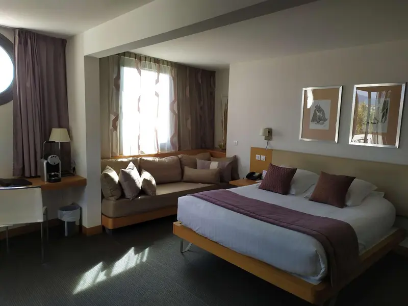 Une chambre lumineuse avec un canapé et un lit.