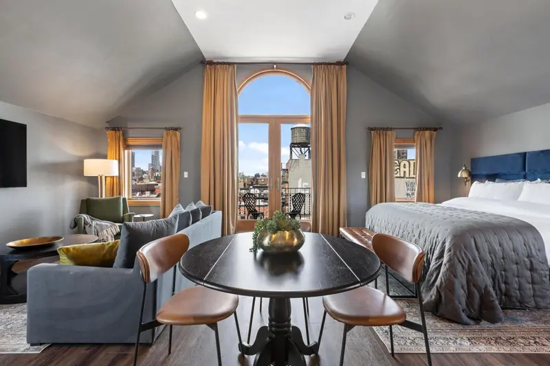 Une chambre avec un coin repas et une vue sur la ville.
