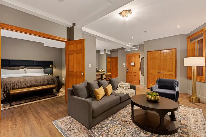 Une chambre spacieuse avec un coin salon et un grand lit.