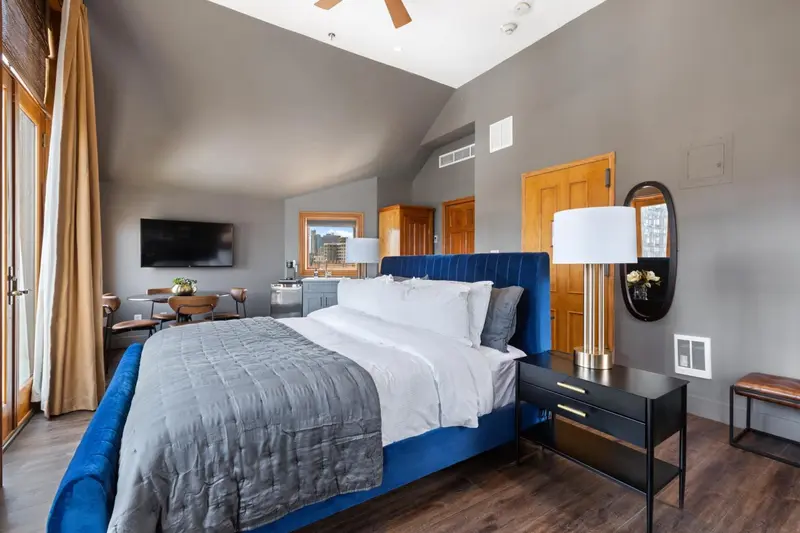 Une chambre spacieuse avec un grand lit et un coin repas.