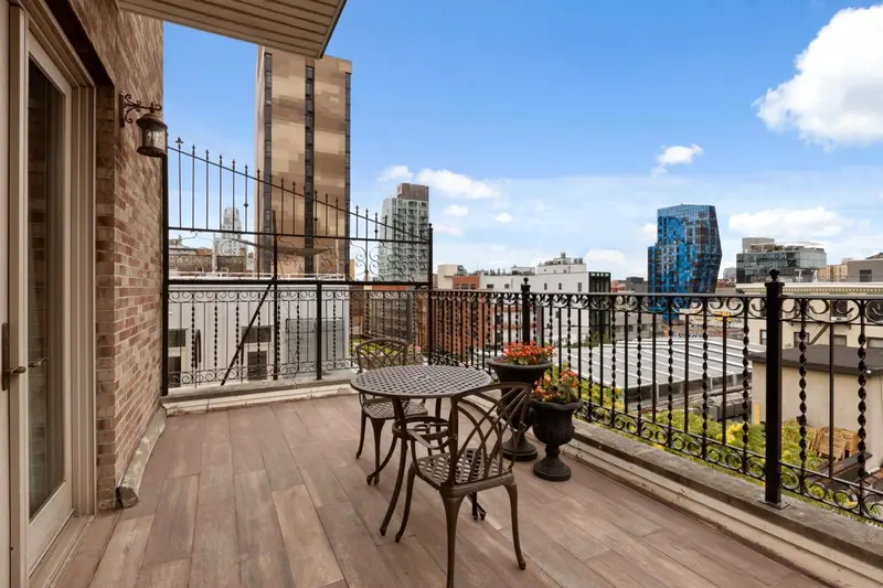 Terrasse avec mobilier en bois et vue sur la ville.