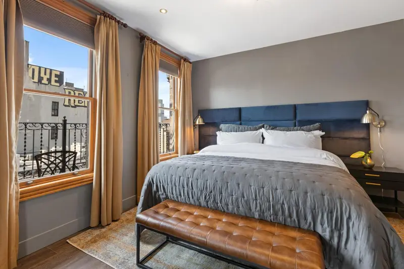 Une chambre avec un grand lit et une fenêtre donnant sur la rue.