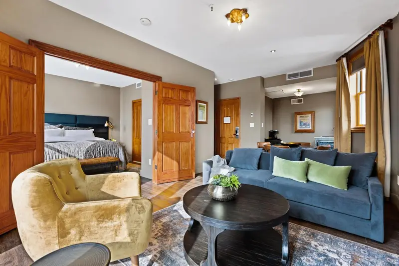 Un salon confortable s'ouvre sur une chambre à coucher.