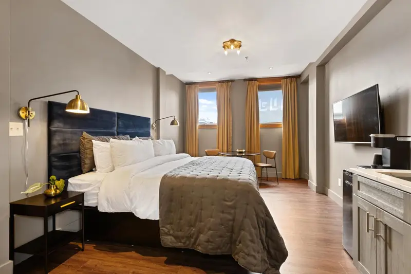 Une chambre d'hôtel moderne avec un grand lit et une télévision murale.