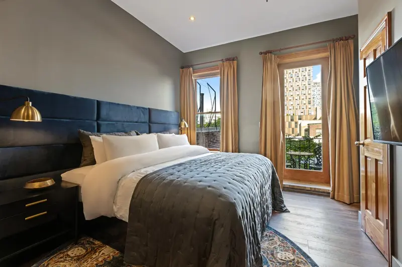 Une chambre avec un grand lit et une fenêtre donnant sur la ville.