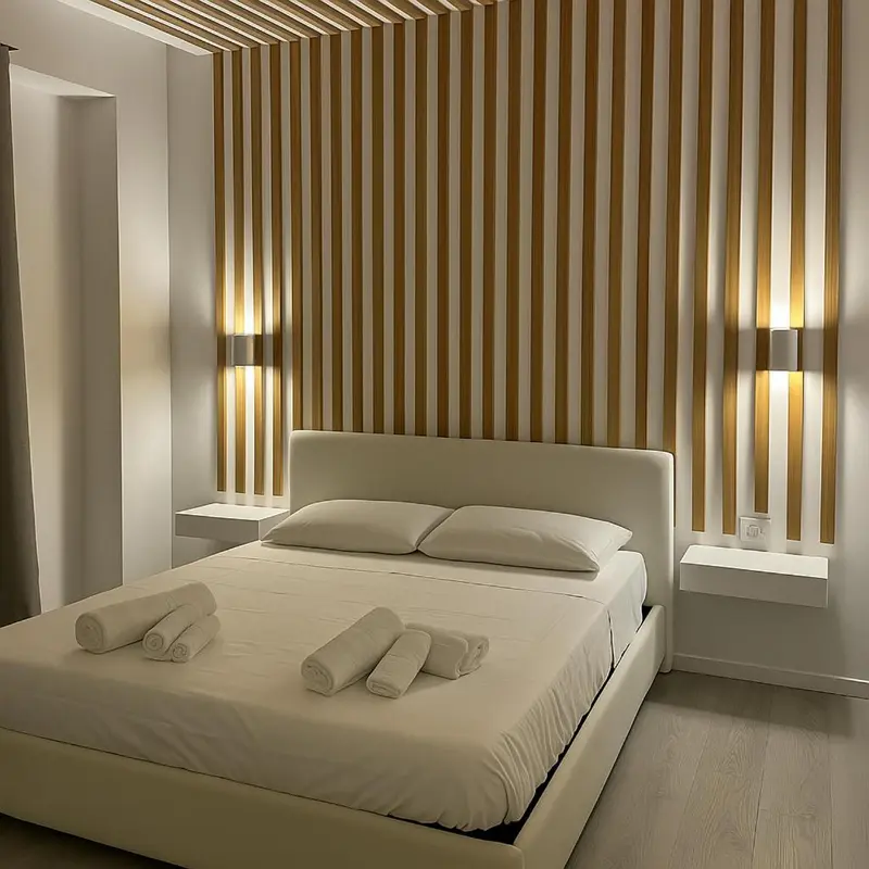 Une chambre lumineuse avec un grand lit et un mur décoratif à rayures.