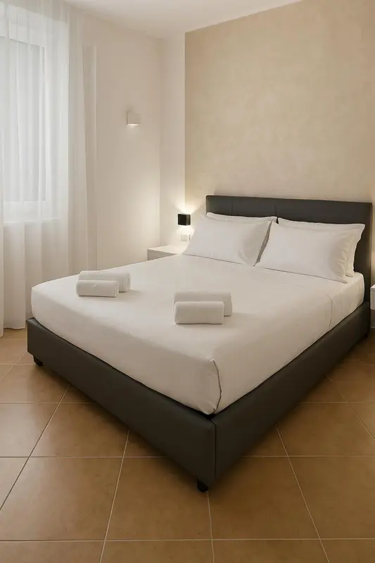 Une chambre lumineuse avec un grand lit recouvert de draps blancs.