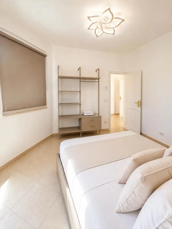 Une chambre lumineuse avec un grand lit et un placard ouvert.