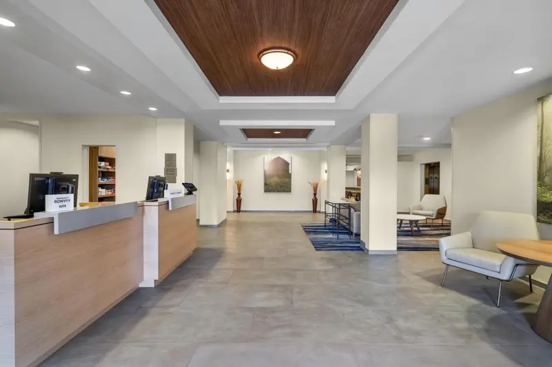 Un comptoir d'accueil lumineux dans un hall d'hôtel moderne.