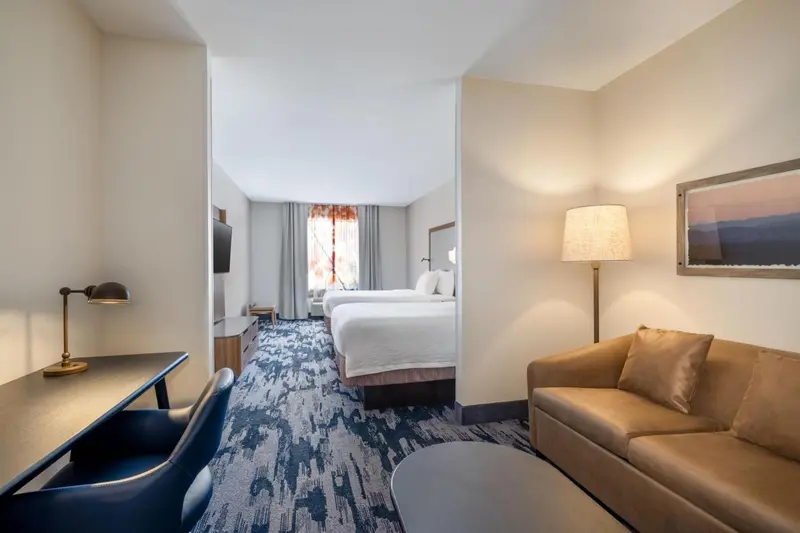 Une chambre lumineuse avec un canapé et un bureau.