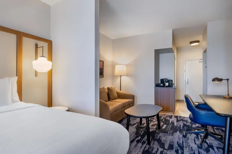 Une chambre d'hôtel lumineuse avec un coin salon et un espace de travail.