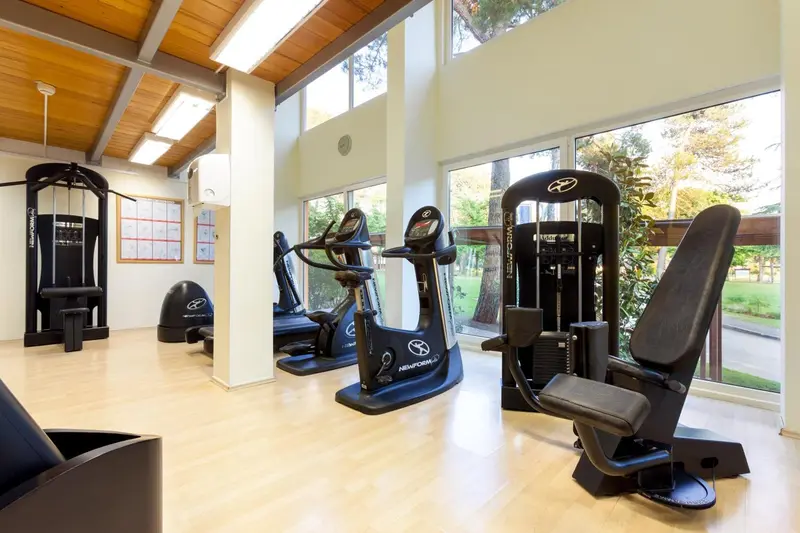 Une salle de sport lumineuse avec des équipements de musculation et cardio.
