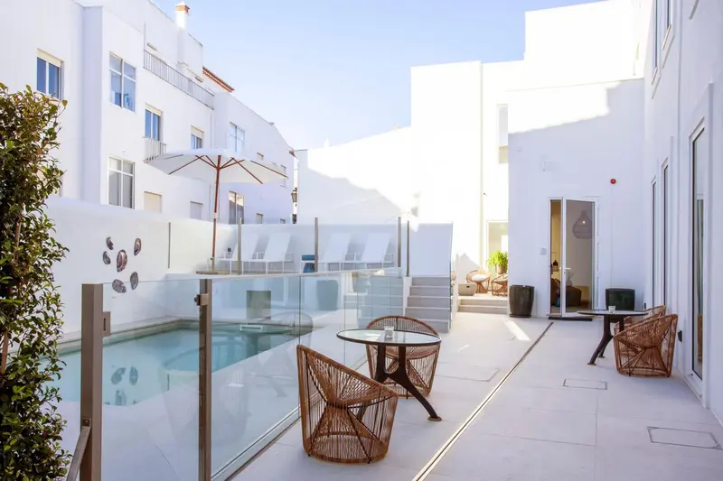 Une cour intérieure lumineuse avec une petite piscine et des meubles de jardin.