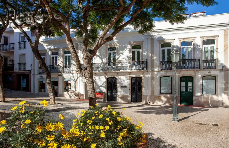 Façade d'un bâtiment blanc à deux étages avec des fenêtres et des balcons.