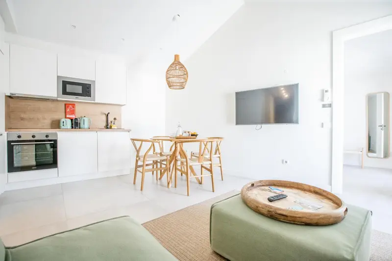 Une cuisine ouverte sur un espace repas et un salon lumineux.