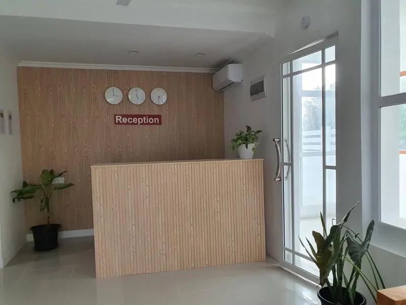 Un comptoir d'accueil avec des horloges murales et des plantes vertes.