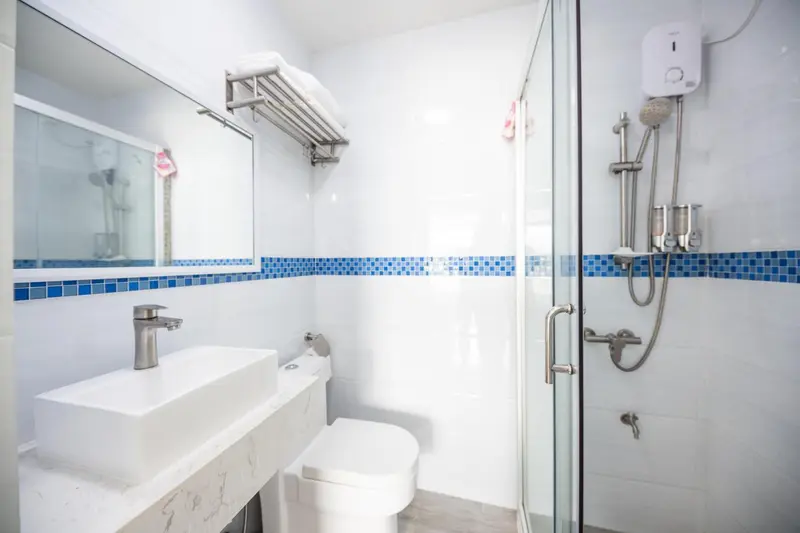 Une salle de bain claire avec douche à l'italienne et lavabo.