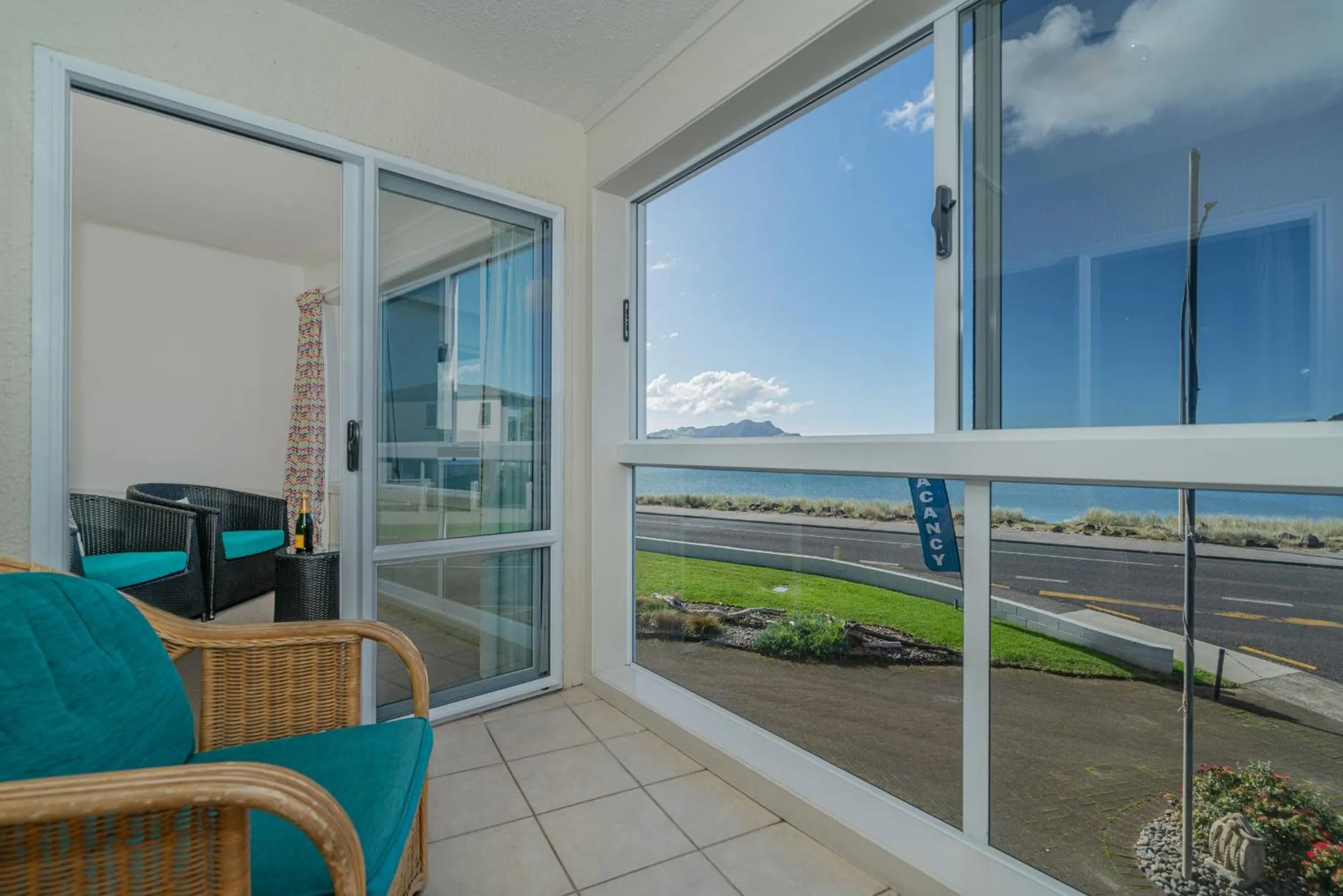 Espace de détente avec mobilier en osier donnant sur une vue mer.