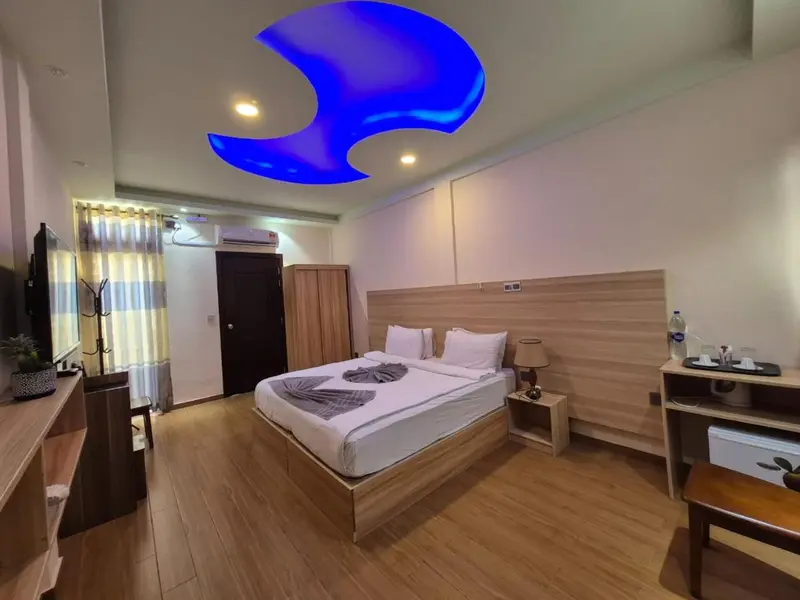 Une chambre lumineuse avec un lit double et un mobilier en bois clair.