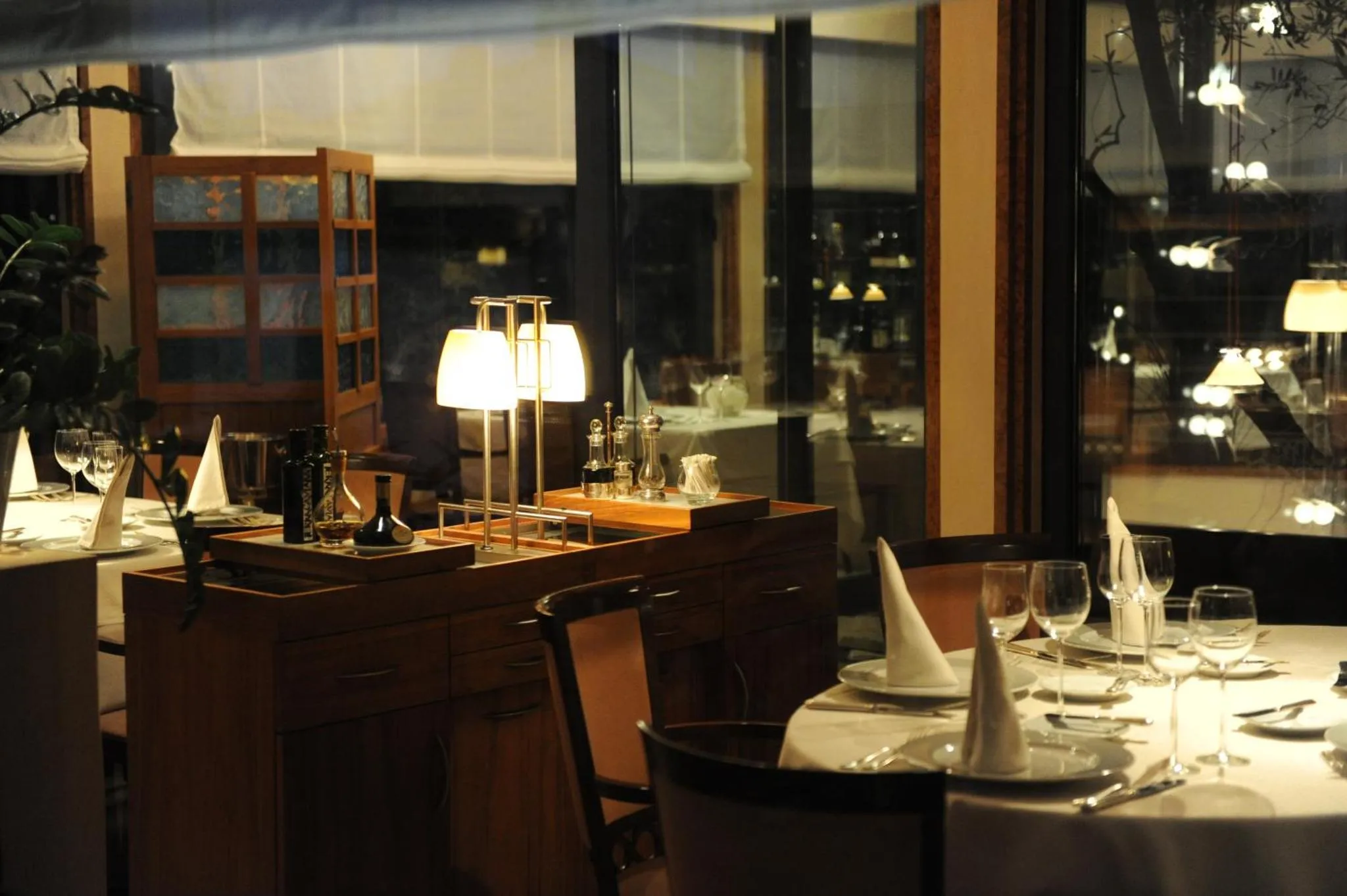 Une table de restaurant est dressée avec des couverts et des verres.