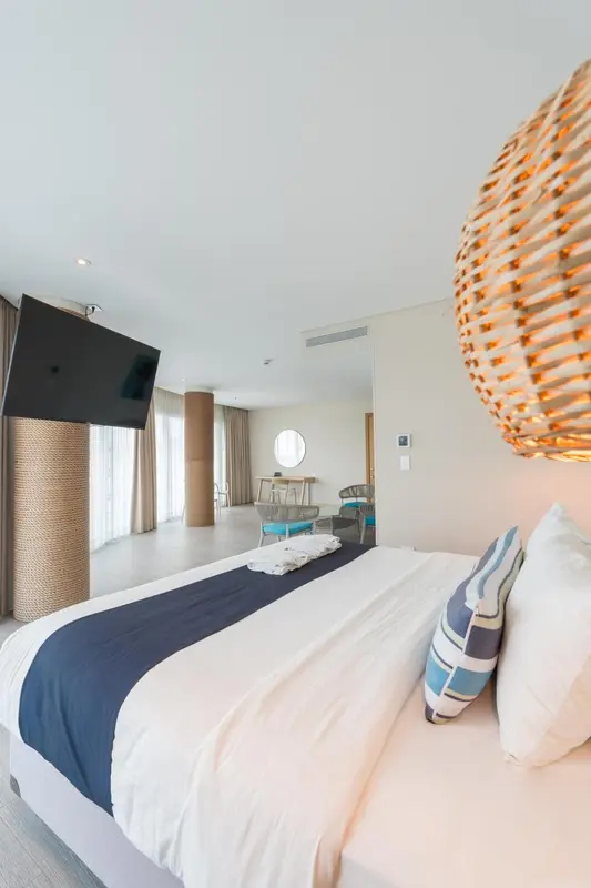 Une chambre lumineuse avec un grand lit et une décoration naturelle.