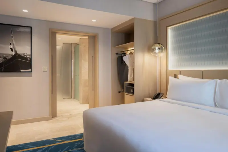 Une chambre lumineuse avec un grand lit et un espace ouvert sur la salle de bain.
