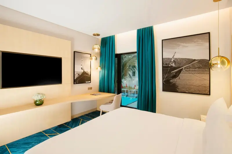 Une chambre lumineuse avec un grand lit et un bureau.