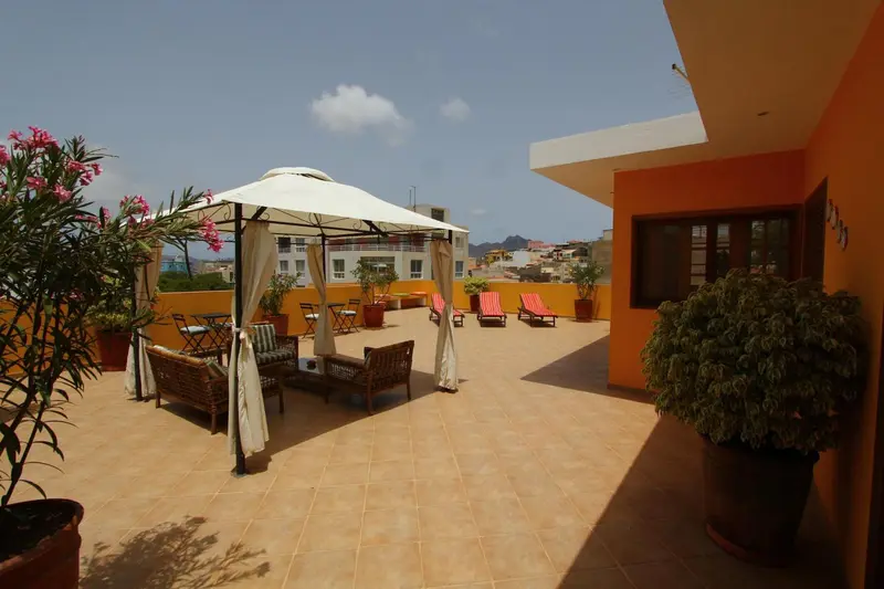 Terrasse aménagée avec des meubles de jardin et des parasols.