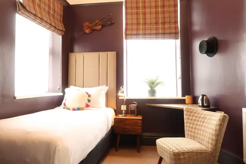 Une chambre à coucher avec un lit simple et une fenêtre.