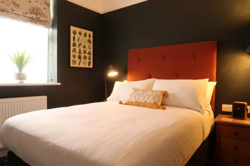 Une chambre avec un grand lit recouvert d'une couette blanche et d'oreillers.
