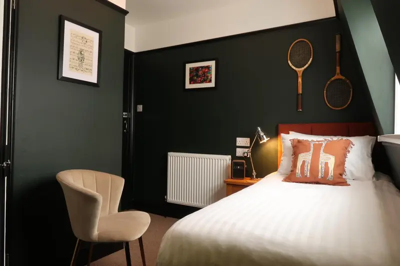Une chambre à coucher avec un lit recouvert d'une courtepointe et un fauteuil.
