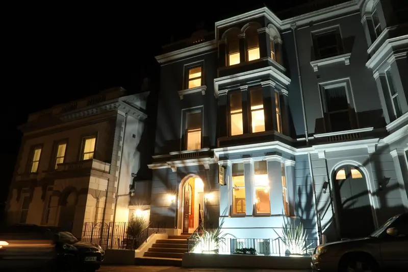 Façade d'un bâtiment illuminé la nuit.