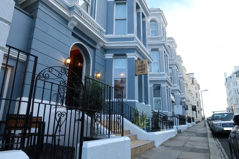 Façade d'un bâtiment bleu avec un balcon et une entrée décorée.