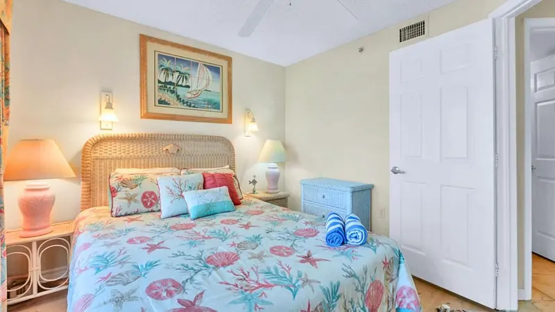 Une chambre lumineuse avec un grand lit recouvert d'une couette à motifs.