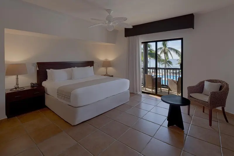 Une chambre lumineuse avec un grand lit et un accès à une terrasse.