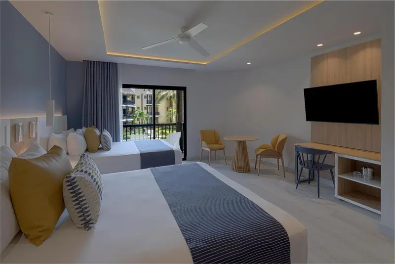 Chambre lumineuse avec un grand lit et un espace détente.