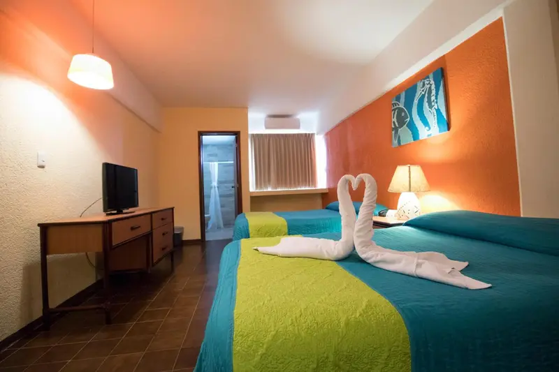 Une chambre lumineuse avec deux lits simples et une décoration colorée.