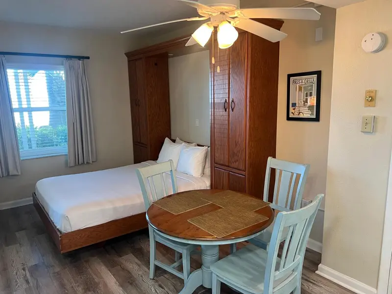 Une chambre lumineuse avec un lit, une table et des chaises.