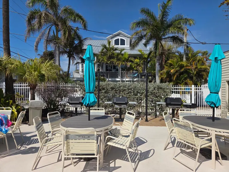 Terrasse avec tables et chaises près de barbecues.