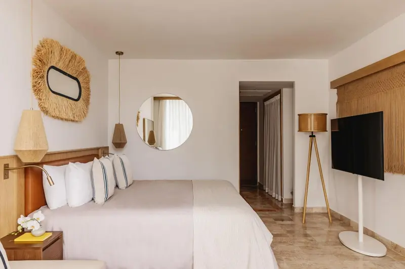 Une chambre lumineuse avec un grand lit et une décoration naturelle.