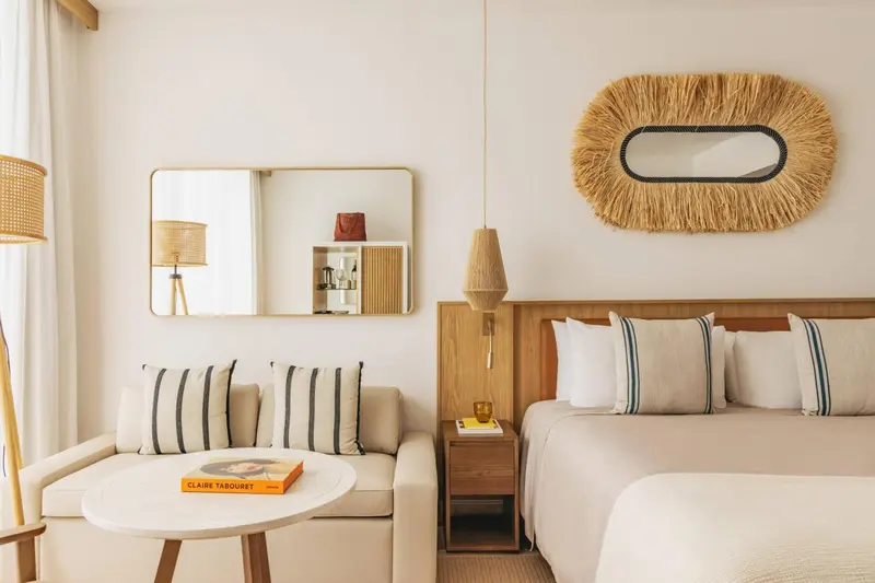 Une chambre lumineuse avec un lit et un coin salon.