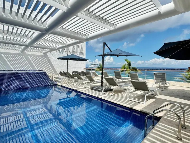 Terrasse avec transats et piscine au bord de la mer.