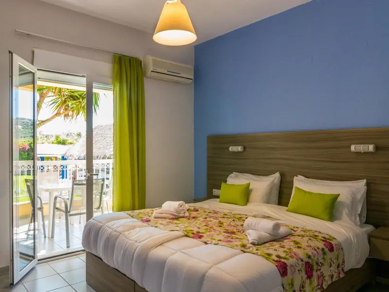 Une chambre lumineuse avec un lit double et un accès à une terrasse.