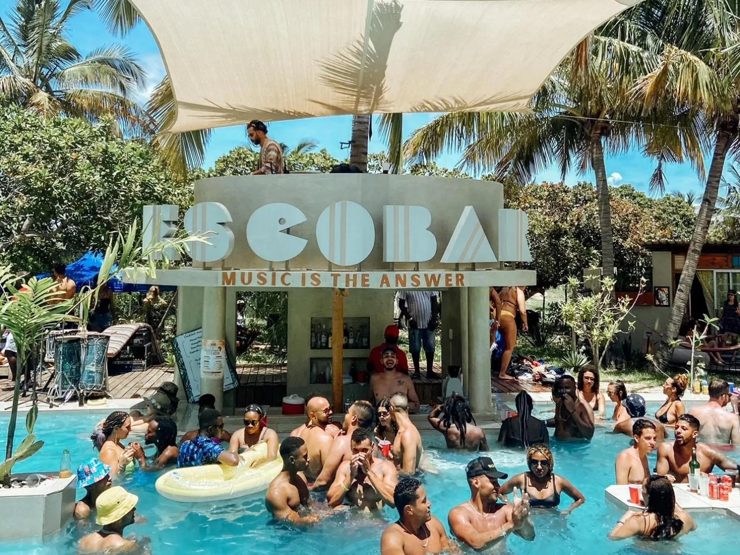 Une piscine animée avec des personnes se rafraîchissant et se détendant au soleil.