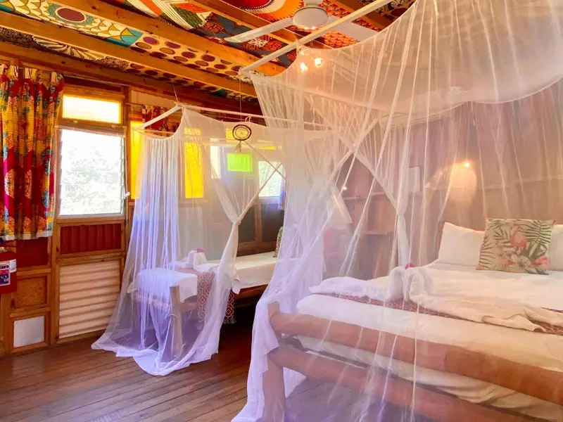 Une chambre lumineuse avec un lit à baldaquin et une décoration colorée.